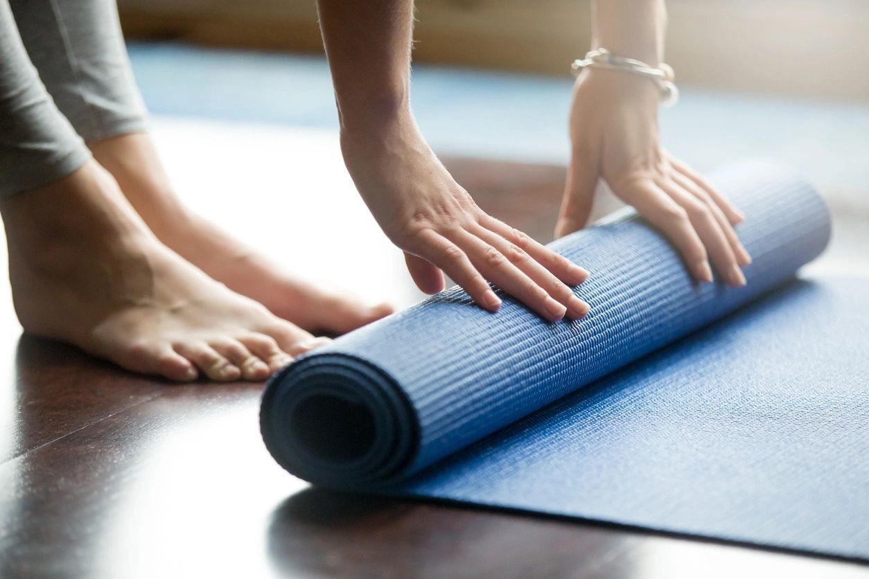 Yoga class West Kilbride image of yogi rolling up mat.